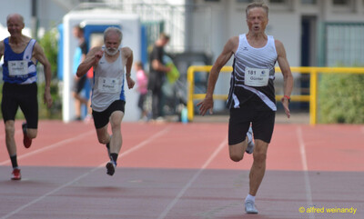 Drei Personen der Seniorenklasse sprinten Seite an Seite über die Tartanbahn beim Walfried-Heinz-Sportfest der TG Konz im Saar-Mosel-Stadion in Konz.
