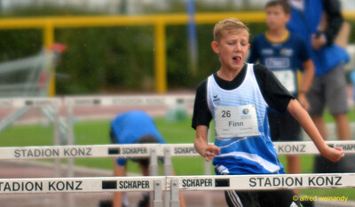 Ein Kind läuft konzentriert über den Hürdenlauf beim Walfried-Heinz-Sportfest der TG Konz im Saar-Mosel-Stadion in Konz.