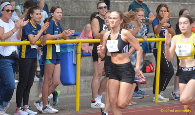 Mehrere Aktive sprinten auf der Rundbahn vor Zuschauenden beim Walfried-Heinz-Sportfest der TG Konz im Saar-Mosel-Stadion in Konz.