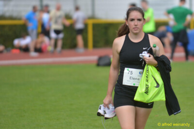 Eine Person geht mit Schuhen und Tasche über den Rasen beim Walfried-Heinz-Sportfest der TG Konz im Saar-Mosel-Stadion in Konz.