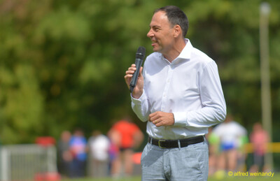 Eine Person spricht ins Mikrofon beim Walfried-Heinz-Sportfest der TG Konz im Saar-Mosel-Stadion in Konz.