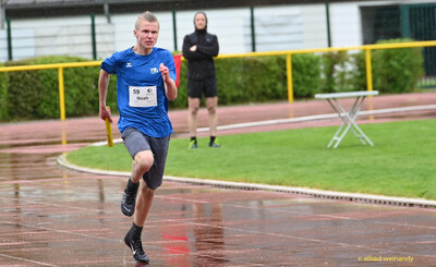 Ein Kind rennt mit dem Staffelstab in der Hand über die nasse Bahn beim Walfried-Heinz-Sportfest der TG Konz im Saar-Mosel-Stadion in Konz.