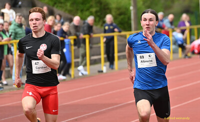 Zwei Aktive sprinten nebeneinander auf der Rundbahn beim Walfried-Heinz-Sportfest der TG Konz im Saar-Mosel-Stadion in Konz.