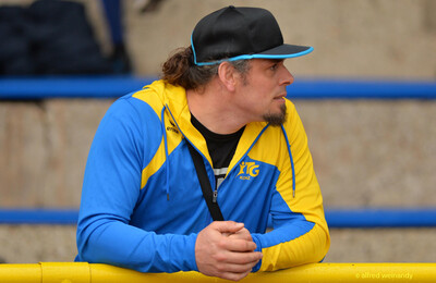 Eine Person in TG-Konz-Jacke verfolgt das Geschehen am Geländer beim Walfried-Heinz-Sportfest der TG Konz im Saar-Mosel-Stadion in Konz.