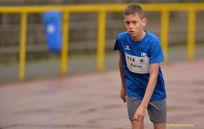 Ein Kind mit Startnummer steht erschöpft auf der Tartanfläche beim Walfried-Heinz-Sportfest der TG Konz im Saar-Mosel-Stadion in Konz.