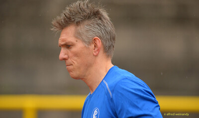 Seitliches Porträt einer Person mit grauen Haaren im blauen Shirt beim Walfried-Heinz-Sportfest der TG Konz im Saar-Mosel-Stadion in Konz.