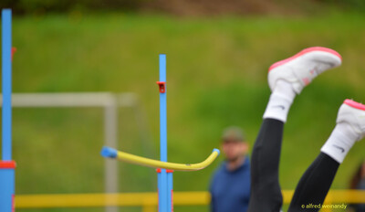 Beine einer Person ragen über die Matte hinter der Hochsprunglatte beim Walfried-Heinz-Sportfest der TG Konz im Saar-Mosel-Stadion in Konz.