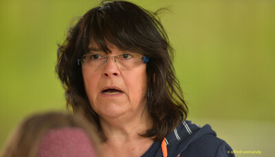 Nahaufnahme einer Person mit Brille und dunklen Haaren am Rand der Wettkampfbahn beim Walfried-Heinz-Sportfest der TG Konz im Saar-Mosel-Stadion in Konz.