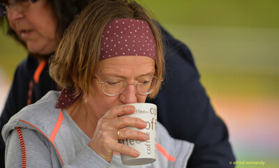 Eine Person trinkt im Zelt einen Kaffee aus einer Tasse beim Walfried-Heinz-Sportfest der TG Konz im Saar-Mosel-Stadion in Konz.
