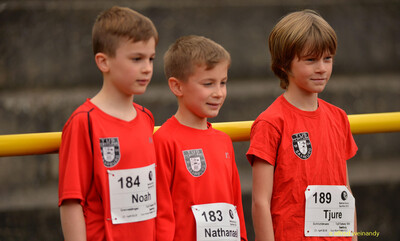 Drei junge Teilnehmende mit Startnummern stehen nebeneinander beim Walfried-Heinz-Sportfest der TG Konz im Saar-Mosel-Stadion in Konz.