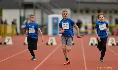 Drei Kinder sprinten über die Laufbahn beim Walfried-Heinz-Sportfest der TG Konz im Saar-Mosel-Stadion in Konz.