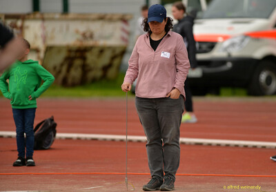 Eine Person im Kampfgericht steht mit einem Messstab an einer Markierung auf der Bahn beim Walfried-Heinz-Sportfest der TG Konz im Saar-Mosel-Stadion in Konz.