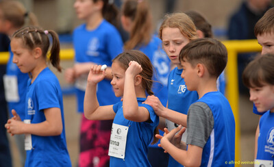 Eine Gruppe Kinder in blauen Trikots steht zusammen und wärmt sich auf beim Walfried-Heinz-Sportfest der TG Konz im Saar-Mosel-Stadion in Konz.