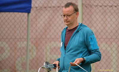 Eine Person im Kampfgericht hält ein Maßband zum Ausmessen einer Weite beim Walfried-Heinz-Sportfest der TG Konz im Saar-Mosel-Stadion in Konz.