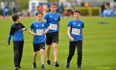 Vier Kinder der TG Konz gehen gemeinsam über den Rasen beim Walfried-Heinz-Sportfest der TG Konz im Saar-Mosel-Stadion in Konz.