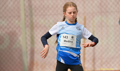 Ein Kind im blau-weißen Trikot mit Startnummer 143 in Bewegung beim Walfried-Heinz-Sportfest der TG Konz im Saar-Mosel-Stadion in Konz