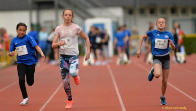 Drei Kinder sprinten mit Startnummern in ihren Bahnen beim Walfried-Heinz-Sportfest der TG Konz im Saar-Mosel-Stadion in Konz.