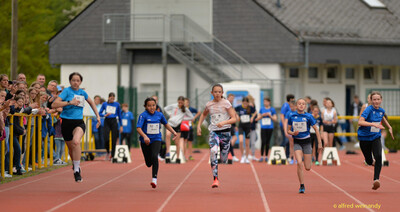 Kinder sprinten nebeneinander auf der Bahn dem Ziel entgegen beim Walfried-Heinz-Sportfest der TG Konz im Saar-Mosel-Stadion in Konz.