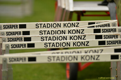 Aufgereihte Hürden mit der Aufschrift Stadion Konz beim Walfried-Heinz-Sportfest der TG Konz im Saar-Mosel-Stadion in Konz.