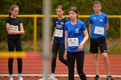 Mehrere Kinder stehen mit Startnummern in einer Reihe und warten auf ihren Wettkampf beim Walfried-Heinz-Sportfest der TG Konz im Saar-Mosel-Stadion in Konz.