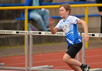 Ein Kind läuft beim Hürdenlauf an den Hürden entlang beim Walfried-Heinz-Sportfest der TG Konz im Saar-Mosel-Stadion in Konz.