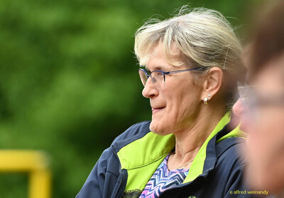 Eine Person mit Brille blickt im Profil aufmerksam zur Seite am Rand der Sportanlage bei der Rheinland-Meisterschaft im Mehrkampf der TG Konz in Konz.