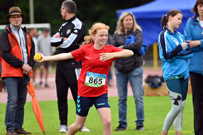 Ein Kind mit der Startnummer 865 holt mit dem gelben Schlagball zum Wurf aus bei der Rheinland-Meisterschaft im Mehrkampf der TG Konz in Konz.