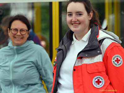Zwei lächelnde Personen im Helferdienst, eine im Sanitätsdienst, posieren bei der Rheinland-Meisterschaft im Mehrkampf der TG Konz in Konz.