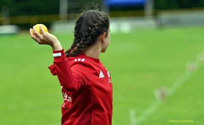 Ein Kind bereitet den Wurf mit dem gelben Schlagball vor bei der Rheinland-Meisterschaft im Mehrkampf der TG Konz in Konz.