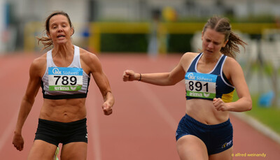Zwei Aktive laufen im Zieleinlauf eines Sprints über die Rundbahn bei der Rheinland-Meisterschaft im Mehrkampf der TG Konz in Konz.