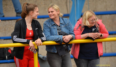 Drei Zuschauende stehen an der Absperrung der Tribüne bei der Rheinland-Pfalz-Meisterschaft in Konz.