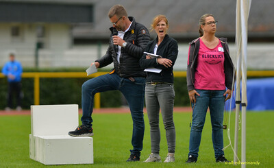 Personen im Helferdienst und eine Person mit Mikrofon stehen auf dem Innenraum bei der Rheinland-Pfalz-Meisterschaft in Konz.