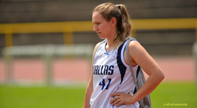 Eine Person im weißen Basketballtrikot steht mit einer Tasche auf der Laufbahn bei der Rheinland-Meisterschaft im Mehrkampf der TG Konz in Konz.