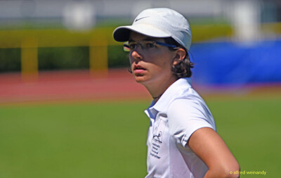 Eine Person mit Cap und Brille blickt zur Seite auf dem Sportgelände bei der Regionsmeisterschaft der Region Trier in Konz.