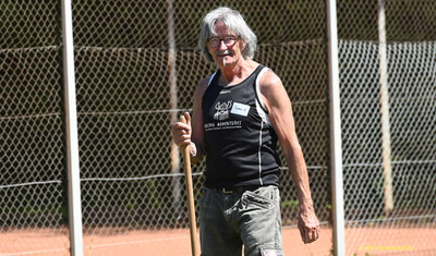 Eine helfende Person mit grauen Haaren und Trägershirt steht mit einem Gerät auf der Wettkampfanlage, bei der Regionsmeisterschaft der Region Trier in Konz.