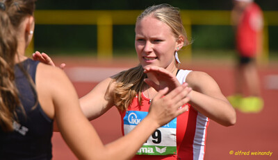 Zwei Aktive klatschen sich nach dem Lauf zur Begrüßung ab beim Mehrkampf der TG Konz in Konz.