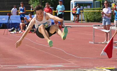 Eine Person in der Flugphase des Weitsprungs kurz vor der Landung beim Mehrkampf der TG Konz in Konz.