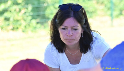 Eine Person mit Sonnenbrille im Haar schaut nach unten beim Kinderleichtathletik-Sportfest der TG Konz im Saar-Mosel-Stadion in Konz