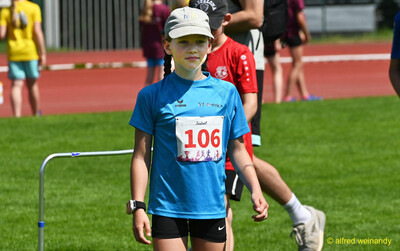 Ein Kind mit Startnummer 106 und Kappe steht auf dem Sportgelände beim Kinderleichtathletik-Sportfest der TG Konz im Saar-Mosel-Stadion in Konz
