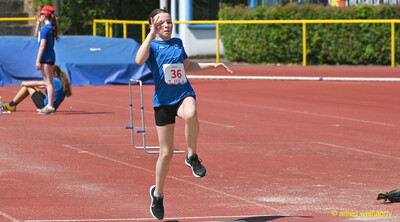 Ein Kind ist beim Absprung in der Flugphase über der roten Bahn beim Kinderleichtathletik-Sportfest der TG Konz im Saar-Mosel-Stadion in Konz