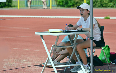 Eine Person notiert am Kampfrichtertisch die Ergebnisse beim Kinderleichtathletik-Sportfest der TG Konz im Saar-Mosel-Stadion in Konz
