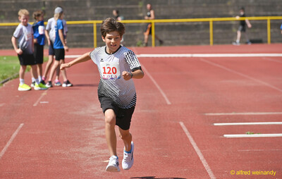 Ein Kind mit Startnummer 120 sprintet über die rote Laufbahn beim Kinderleichtathletik-Sportfest der TG Konz im Saar-Mosel-Stadion in Konz