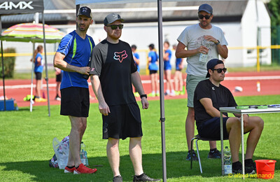 Drei Erwachsene stehen unter einem Zelt am Rand der Anlage beim Kinderleichtathletik-Sportfest der TG Konz im Saar-Mosel-Stadion in Konz
