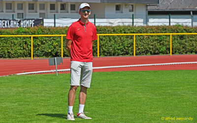 Eine Person im roten Poloshirt steht auf dem Rasen neben der Laufbahn beim Kinderleichtathletik-Sportfest der TG Konz im Saar-Mosel-Stadion in Konz